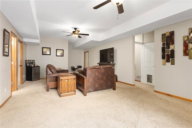 living area with light colored carpet, baseboards, and ceiling fan