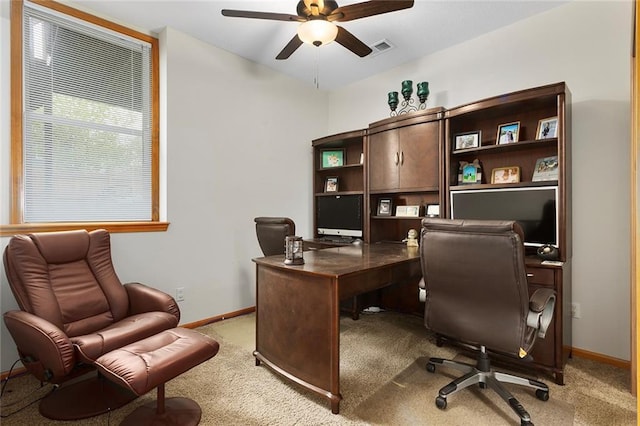 home office with baseboards, ceiling fan, light colored carpet, and visible vents