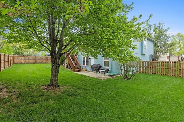 view of yard with a fenced backyard, a patio, and stairway