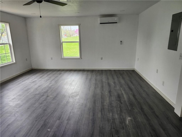 unfurnished room featuring dark wood finished floors, a wall mounted air conditioner, electric panel, baseboards, and ceiling fan