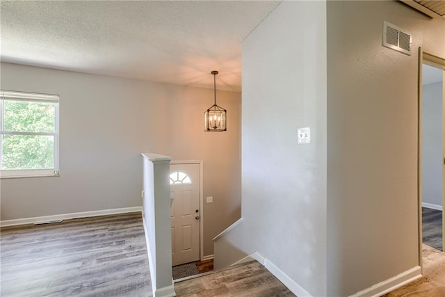 foyer entrance with wood finished floors and baseboards