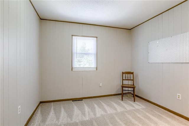 carpeted empty room with baseboards and wooden walls