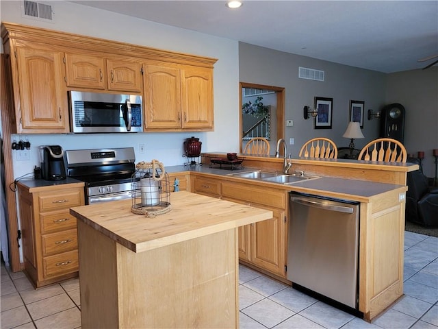 30994 W 98th St, De Soto, KS 66018 - kitchen featuring stainless steel appliances, a sink, butcher block counters, a peninsula, and light tile patterned flooring
