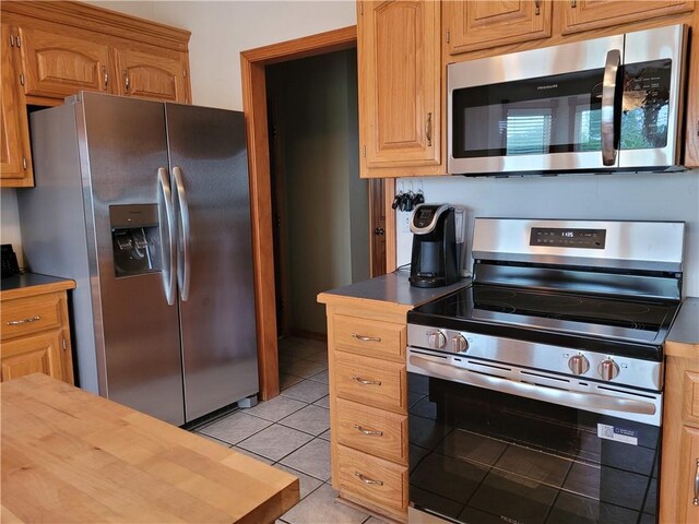30994 W 98th St, De Soto, KS 66018 - kitchen with appliances with stainless steel finishes, light tile patterned flooring, and butcher block counters
