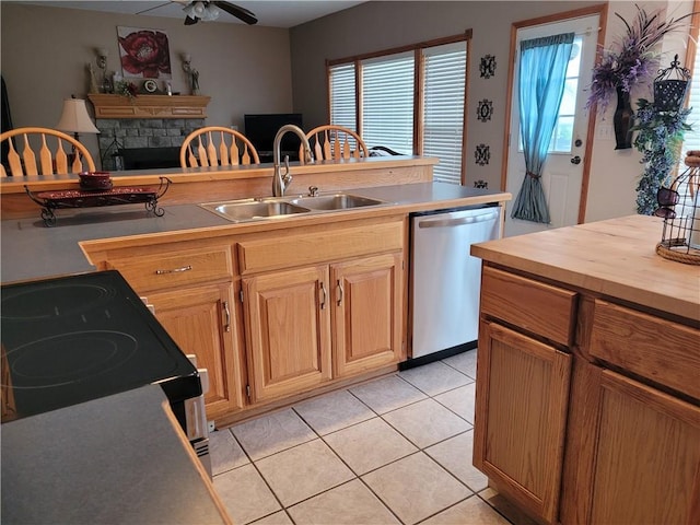 30994 W 98th St, De Soto, KS 66018 - kitchen featuring stainless steel dishwasher, a sink, light tile patterned floors, butcher block counters, and a fireplace