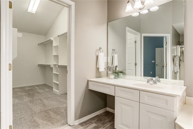 14095 S Mullen St, Olathe, KS 66062 - bathroom featuring a walk in closet, vanity, and baseboards