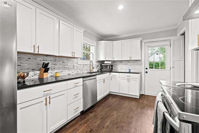 5518 Virginia Ave, Kansas City, MO 64110 - kitchen with stainless steel appliances, decorative backsplash, dark wood-type flooring, white cabinetry, and a sink
