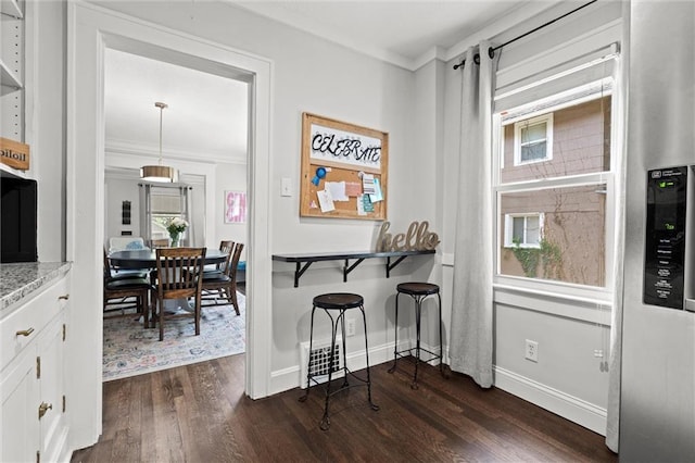 5518 Virginia Ave, Kansas City, MO 64110 - dining area featuring dark wood-type flooring, crown molding, and baseboards