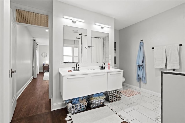 5518 Virginia Ave, Kansas City, MO 64110 - bathroom with double vanity, baseboards, and marble finish flooring