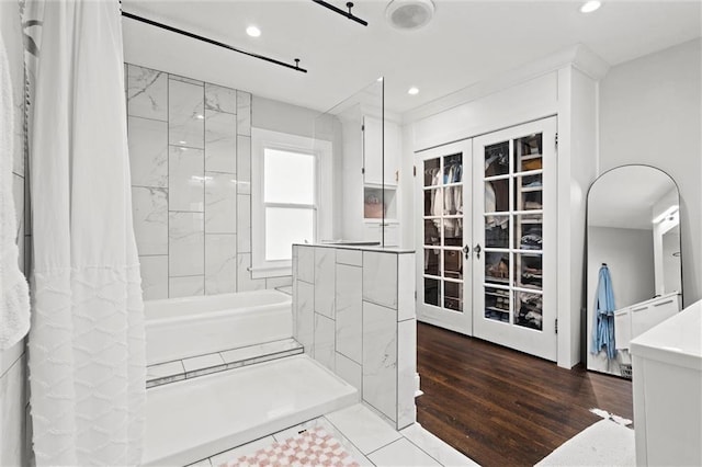5518 Virginia Ave, Kansas City, MO 64110 - bathroom with french doors, a shower with shower curtain, recessed lighting, and wood finished floors
