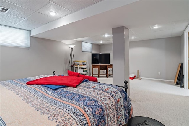 bedroom featuring baseboards, visible vents, a drop ceiling, and carpet