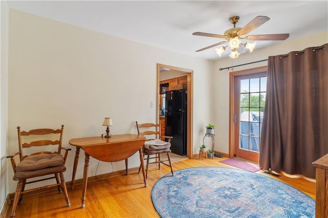 sitting room featuring light wood-style floors, baseboards, and ceiling fan