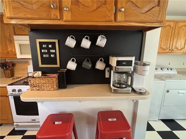 4019 Holly St, Kansas City, MO 64111 - kitchen featuring white appliances, tile patterned floors, washer and dryer, and light countertops