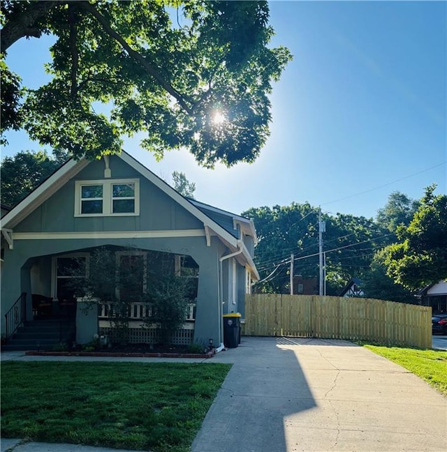 4019 Holly St, Kansas City, MO 64111 - view of home's exterior featuring a porch and stucco siding