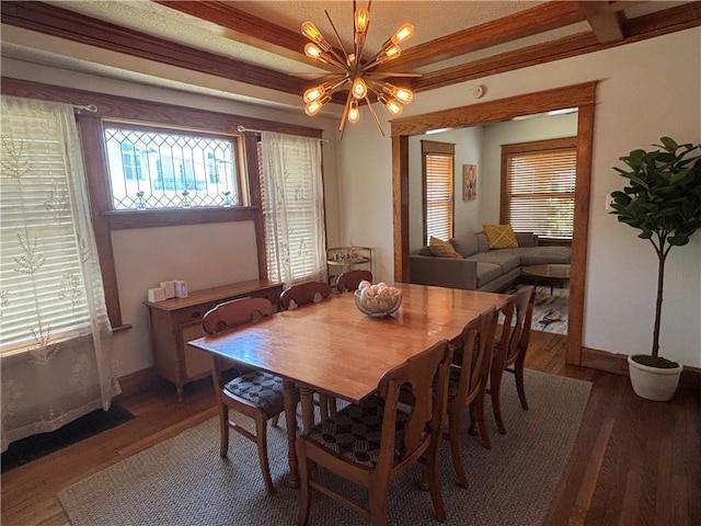 4019 Holly St, Kansas City, MO 64111 - dining area featuring wood finished floors, a chandelier, and healthy amount of natural light