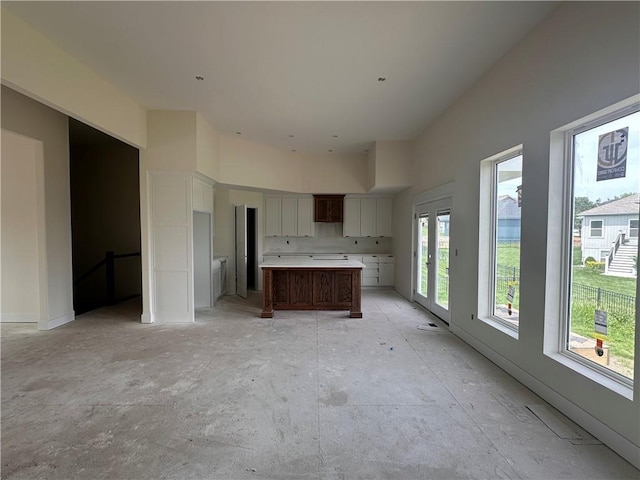 2211 Prairie Creek Dr, Kearney, MO 64060 - kitchen featuring white cabinets, a kitchen island, light countertops, and a high ceiling