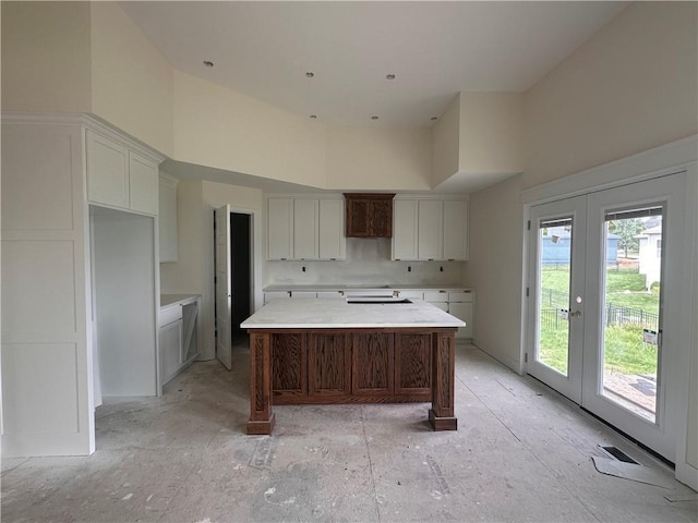 2211 Prairie Creek Dr, Kearney, MO 64060 - kitchen featuring a high ceiling, french doors, a kitchen island, white cabinets, and light countertops
