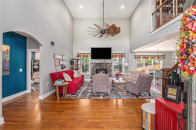 5320 N 101st Ter, Kansas City, KS 66109 - living room featuring a high ceiling, wood finished floors, a fireplace, baseboards, and ceiling fan