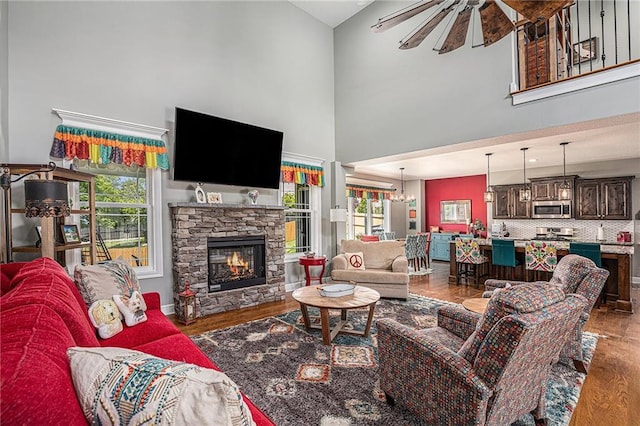 5320 N 101st Ter, Kansas City, KS 66109 - living room featuring a towering ceiling, wood finished floors, a fireplace, a chandelier, and baseboards