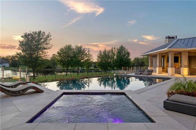 10712 W 165th St, Overland Park, KS 66221 - pool at dusk featuring an in-ground hot tub and a patio area
