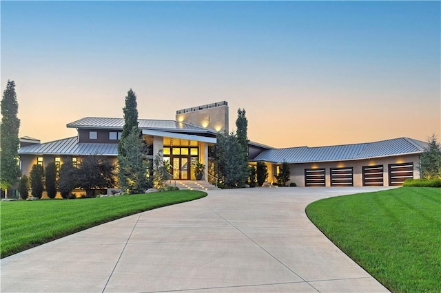 10712 W 165th St, Overland Park, KS 66221 - modern home featuring a standing seam roof, metal roof, concrete driveway, a front lawn, and a garage