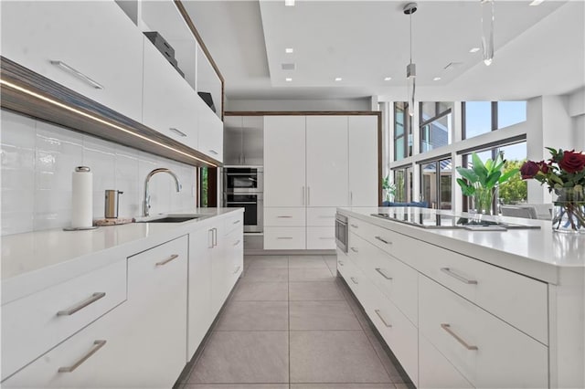 10712 W 165th St, Overland Park, KS 66221 - kitchen with a sink, appliances with stainless steel finishes, modern cabinets, backsplash, and light countertops