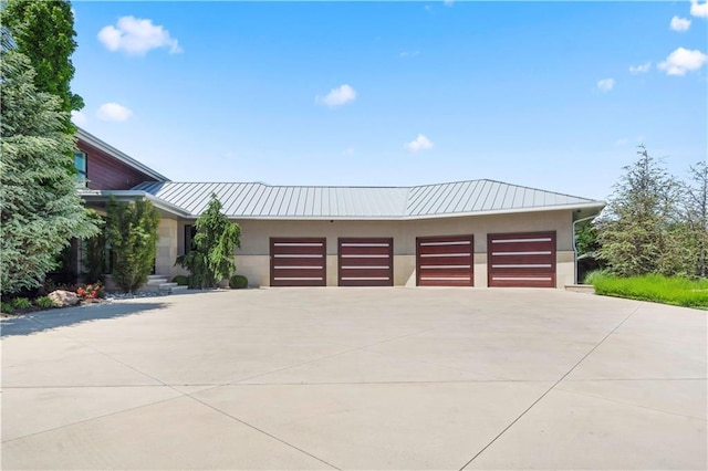 10712 W 165th St, Overland Park, KS 66221 - contemporary home with driveway, a standing seam roof, metal roof, a garage, and stucco siding