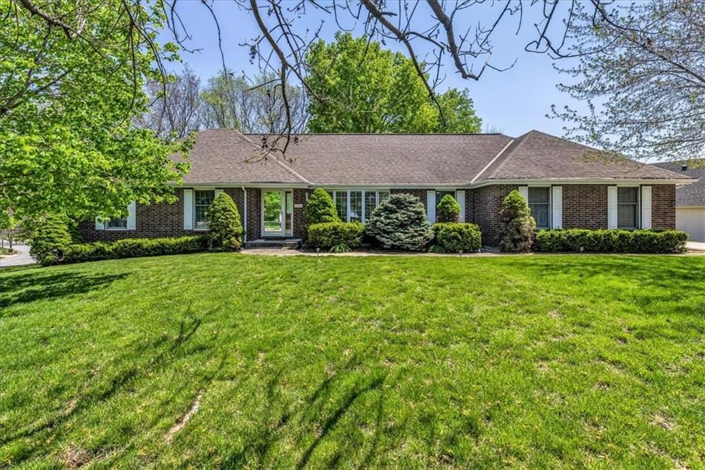 single story home with a front lawn and brick siding