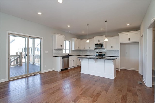 18256 W 166th St, Olathe, KS 66062 - kitchen featuring appliances with stainless steel finishes, dark countertops, white cabinetry, decorative backsplash, and dark wood-style flooring