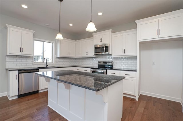 18256 W 166th St, Olathe, KS 66062 - kitchen featuring appliances with stainless steel finishes, white cabinetry, dark wood-type flooring, backsplash, and a center island