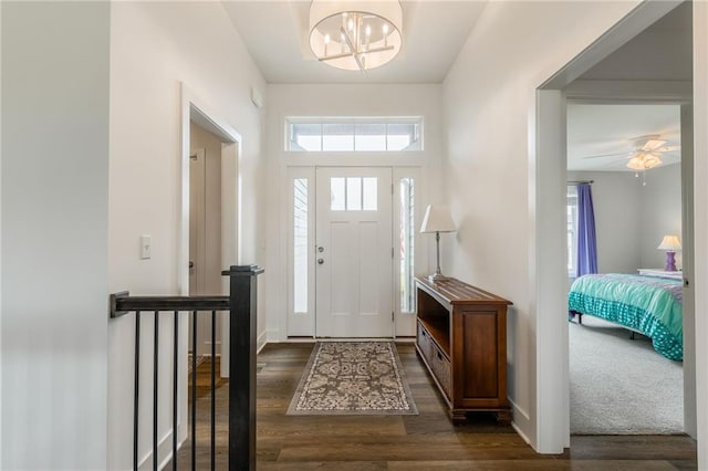 foyer with a chandelier, dark wood finished floors, and a wealth of natural light