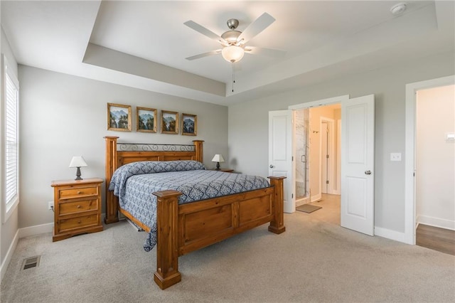 bedroom featuring visible vents, baseboards, ceiling fan, light colored carpet, and a raised ceiling