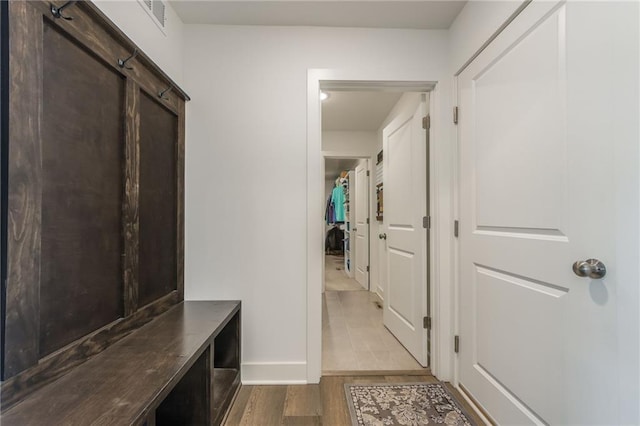 mudroom with baseboards, visible vents, a barn door, and wood finished floors