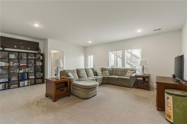 living area with recessed lighting, light colored carpet, and visible vents