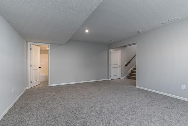empty room featuring baseboards, carpet, visible vents, and stairs