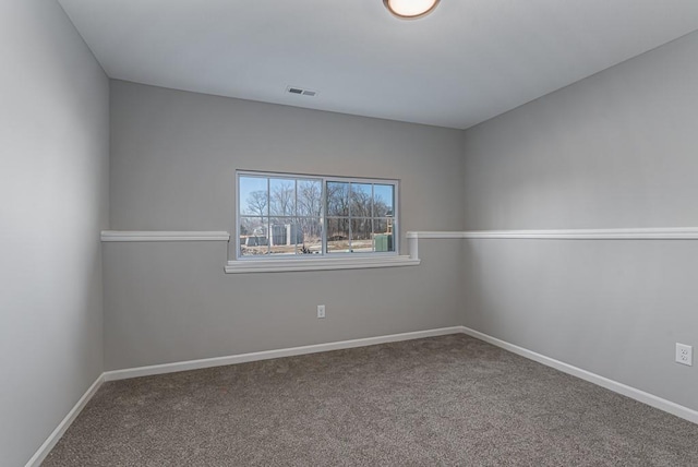 spare room featuring baseboards, visible vents, and carpet