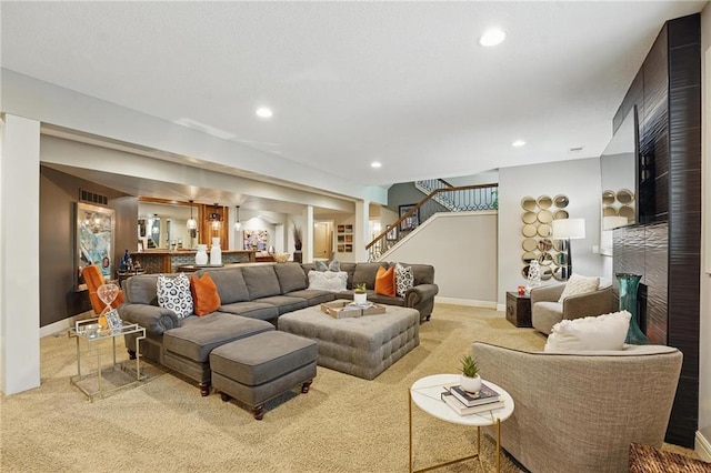 carpeted living area featuring stairs, recessed lighting, baseboards, and a large fireplace