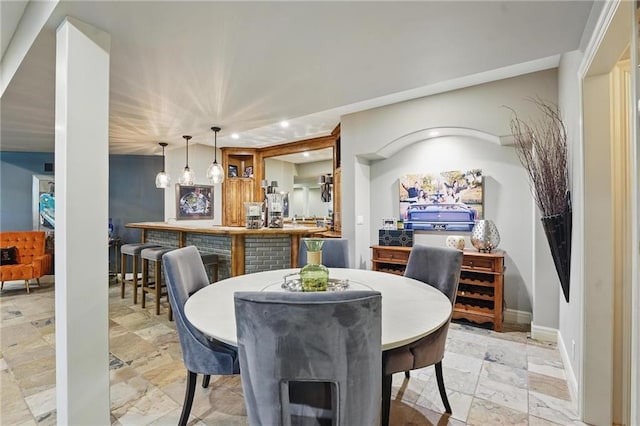 dining area featuring baseboards, recessed lighting, and stone tile flooring