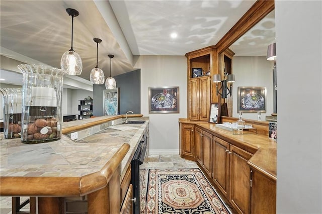 bar featuring a sink, baseboards, and pendant lighting