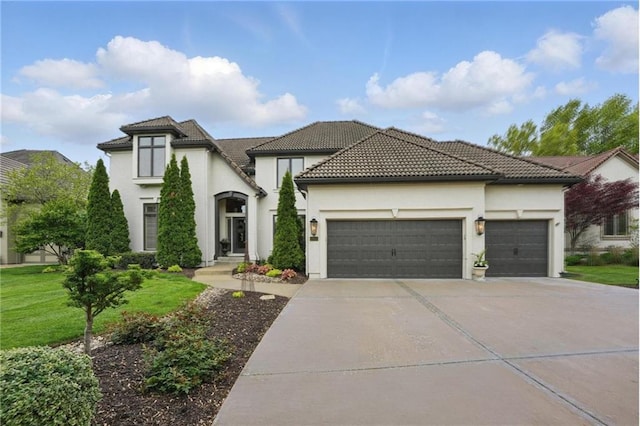 view of front of home featuring a garage, a front yard, stucco siding, concrete driveway, and a tile roof
