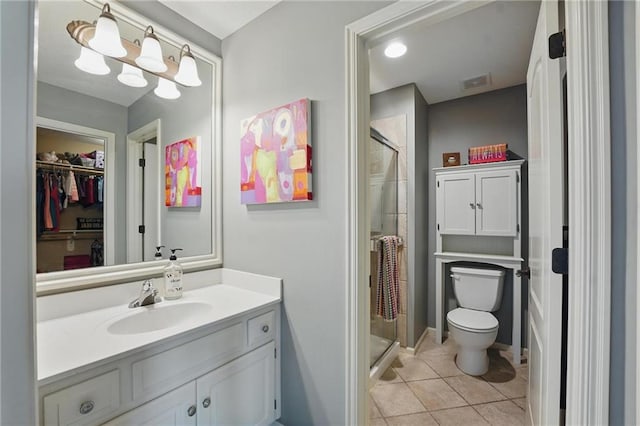 bathroom featuring toilet, a shower stall, tile patterned flooring, and vanity