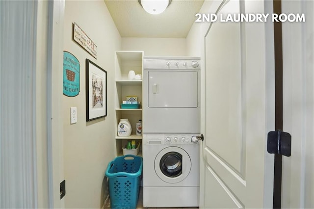 clothes washing area with stacked washer and clothes dryer and laundry area