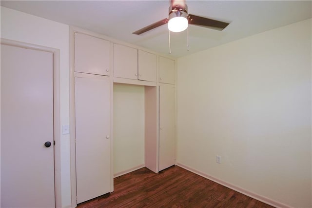 502 W Broadway St, Higginsville, MO 64037 - unfurnished bedroom with dark wood-style floors, a closet, ceiling fan, and baseboards