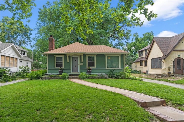 7227 Jefferson St, Kansas City, MO 64114 - view of front of home with a chimney and a front lawn