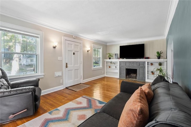 7227 Jefferson St, Kansas City, MO 64114 - living area featuring healthy amount of natural light, ornamental molding, wood finished floors, baseboards, and a brick fireplace