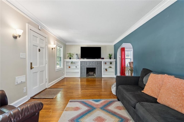 7227 Jefferson St, Kansas City, MO 64114 - living area with ornamental molding, wood finished floors, a brick fireplace, and baseboards