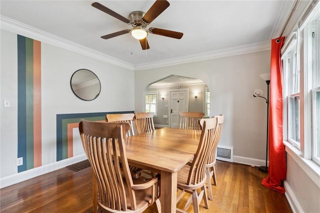 7227 Jefferson St, Kansas City, MO 64114 - dining room featuring arched walkways, crown molding, hardwood / wood-style flooring, baseboards, and a ceiling fan