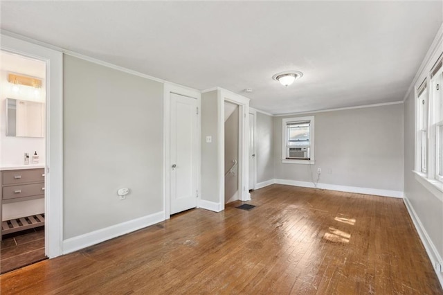 7227 Jefferson St, Kansas City, MO 64114 - unfurnished bedroom featuring wood finished floors, cooling unit, baseboards, connected bathroom, and crown molding