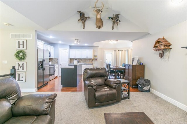 1215 Nottingham Dr, Warrensburg, MO 64093 - living area with baseboards, vaulted ceiling, light carpet, and visible vents