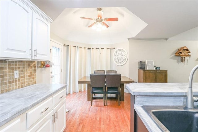 1215 Nottingham Dr, Warrensburg, MO 64093 - kitchen with ceiling fan, light countertops, white cabinets, a sink, and backsplash